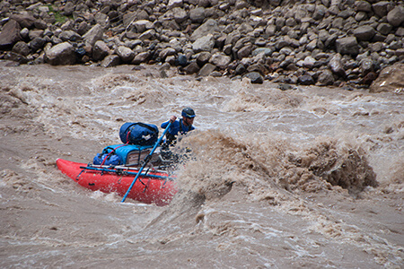 Steve powers through a wave in the cataraft