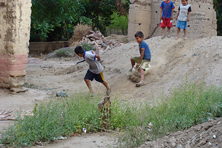 Kids sledding on a dirt pile