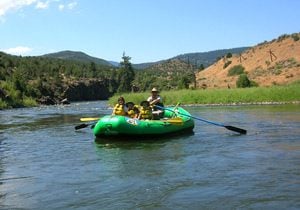a raft with kids smile while kremmling colorado rafting
