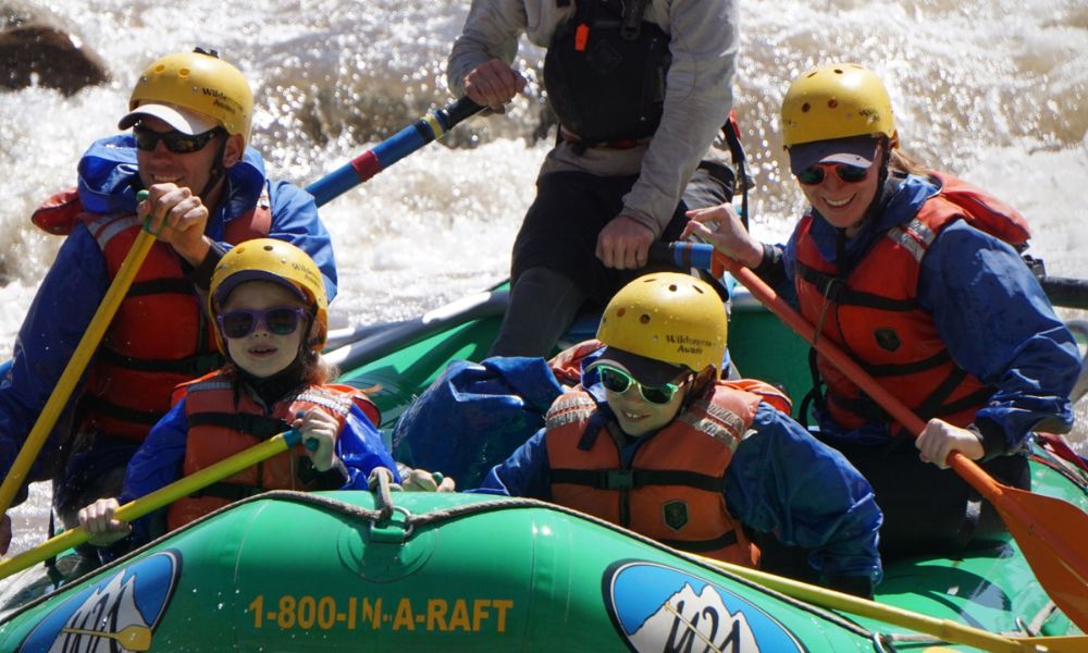 A family in a green boat paddles down the salt river